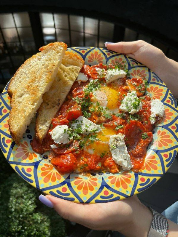 Fried eggs with salami in tomato stew