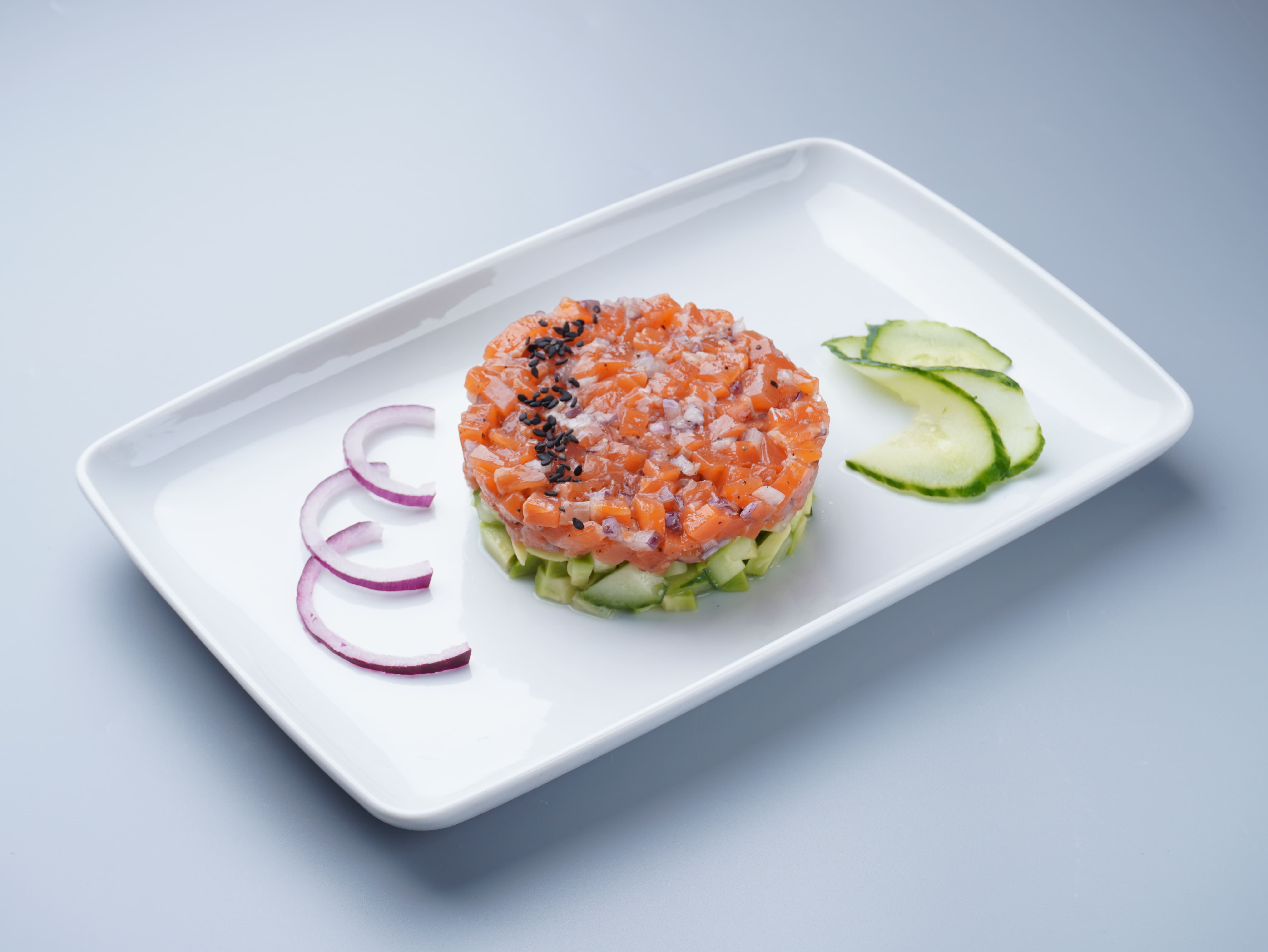 Тартар з лососем, огірком, цибулею та авокадо (100 грам)