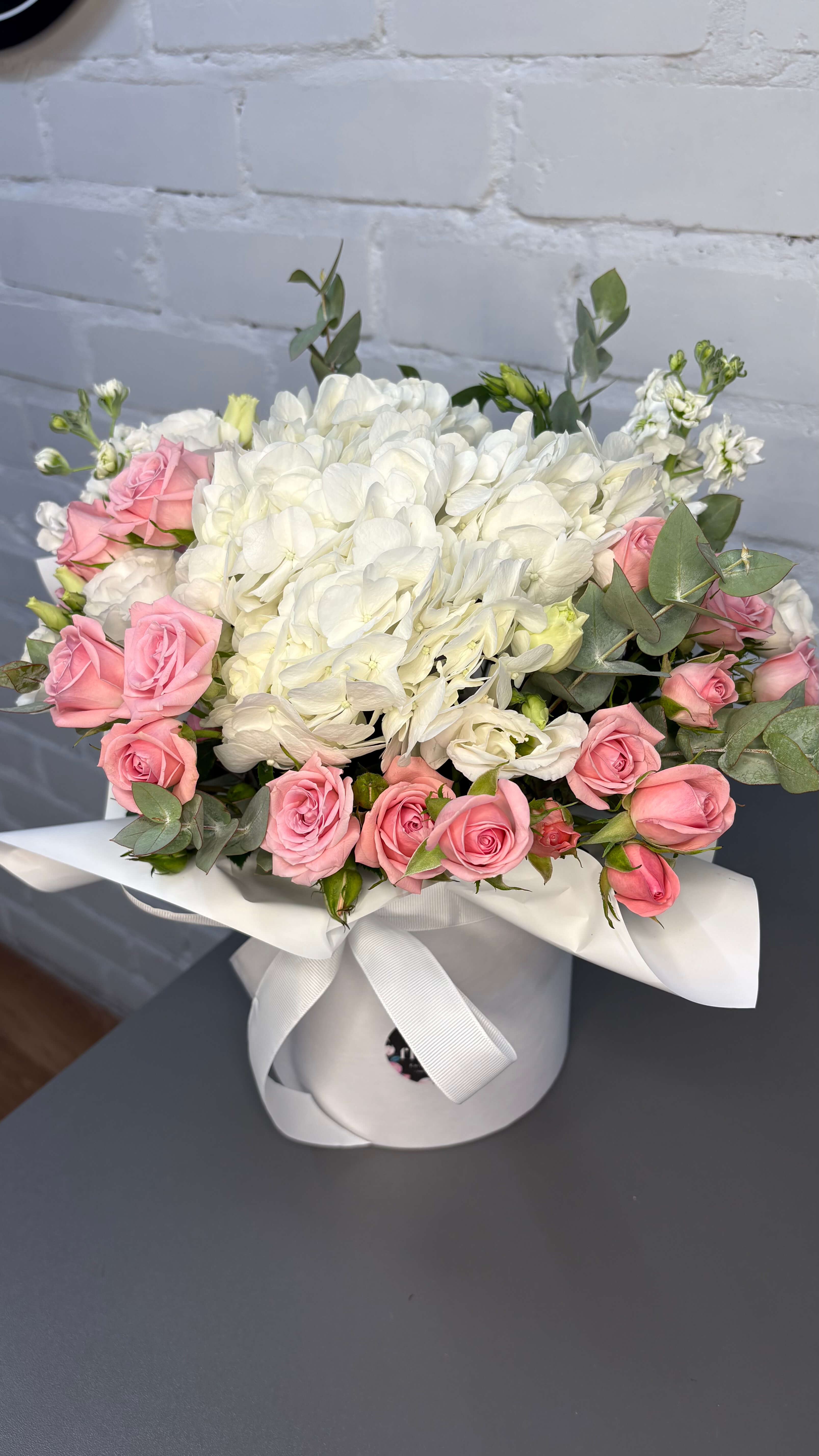 Композиція в коробці з ніжно- рожевою кущовою трояндою та білою гортензією