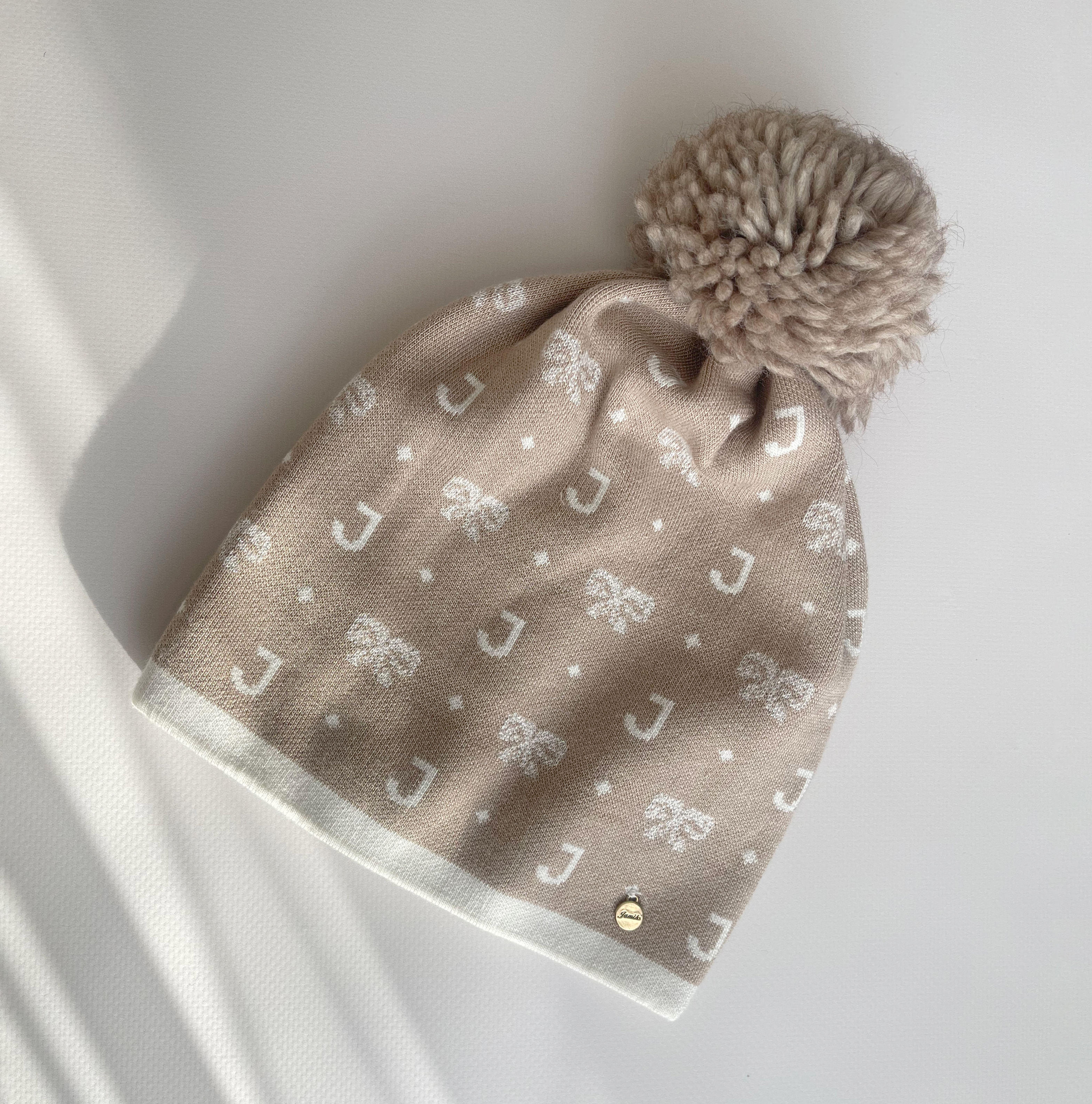 Бежева шапка з помпоном