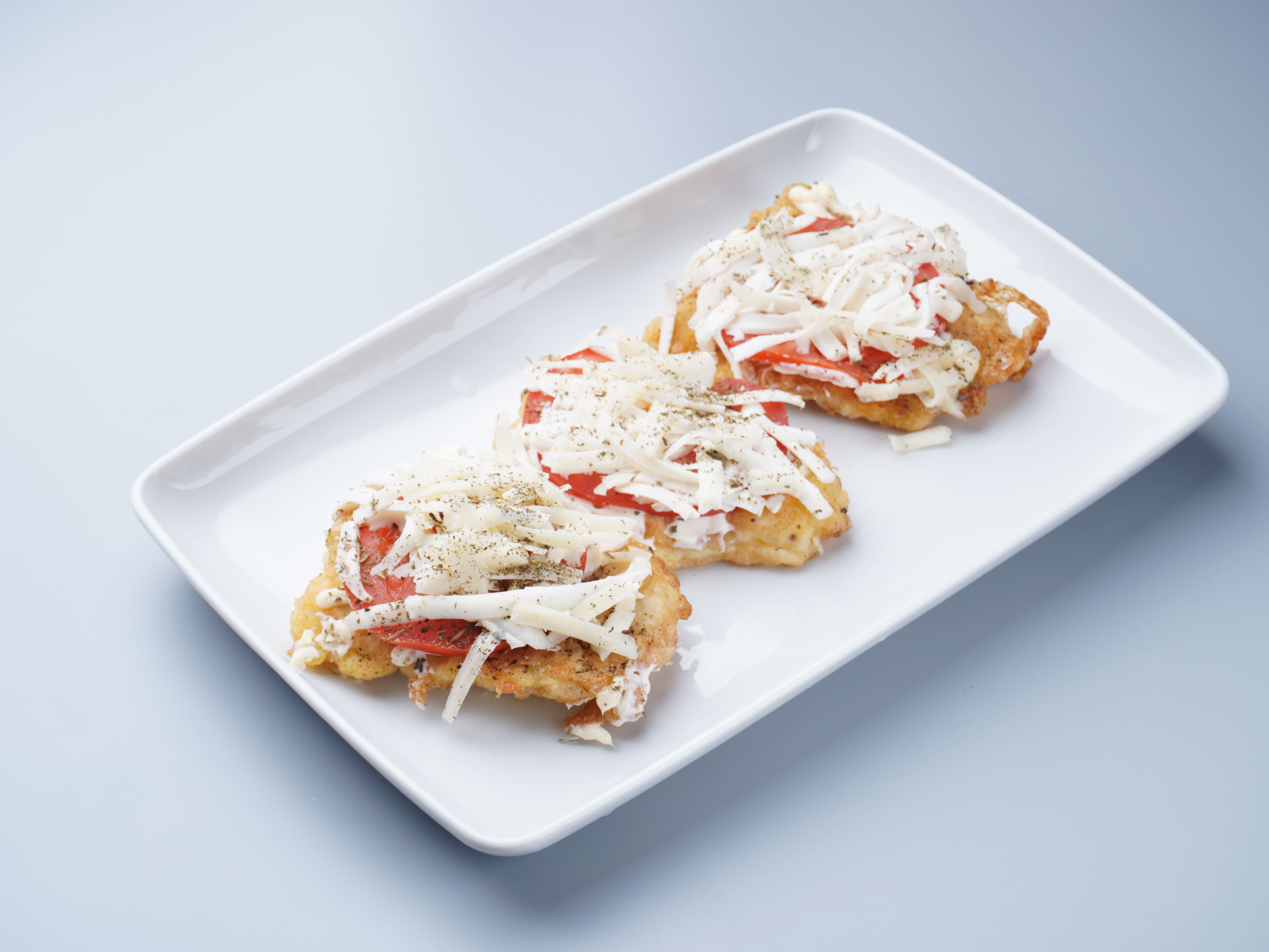 Філе хека "по-італійськи" з моцареллою та томатом (100 грам)