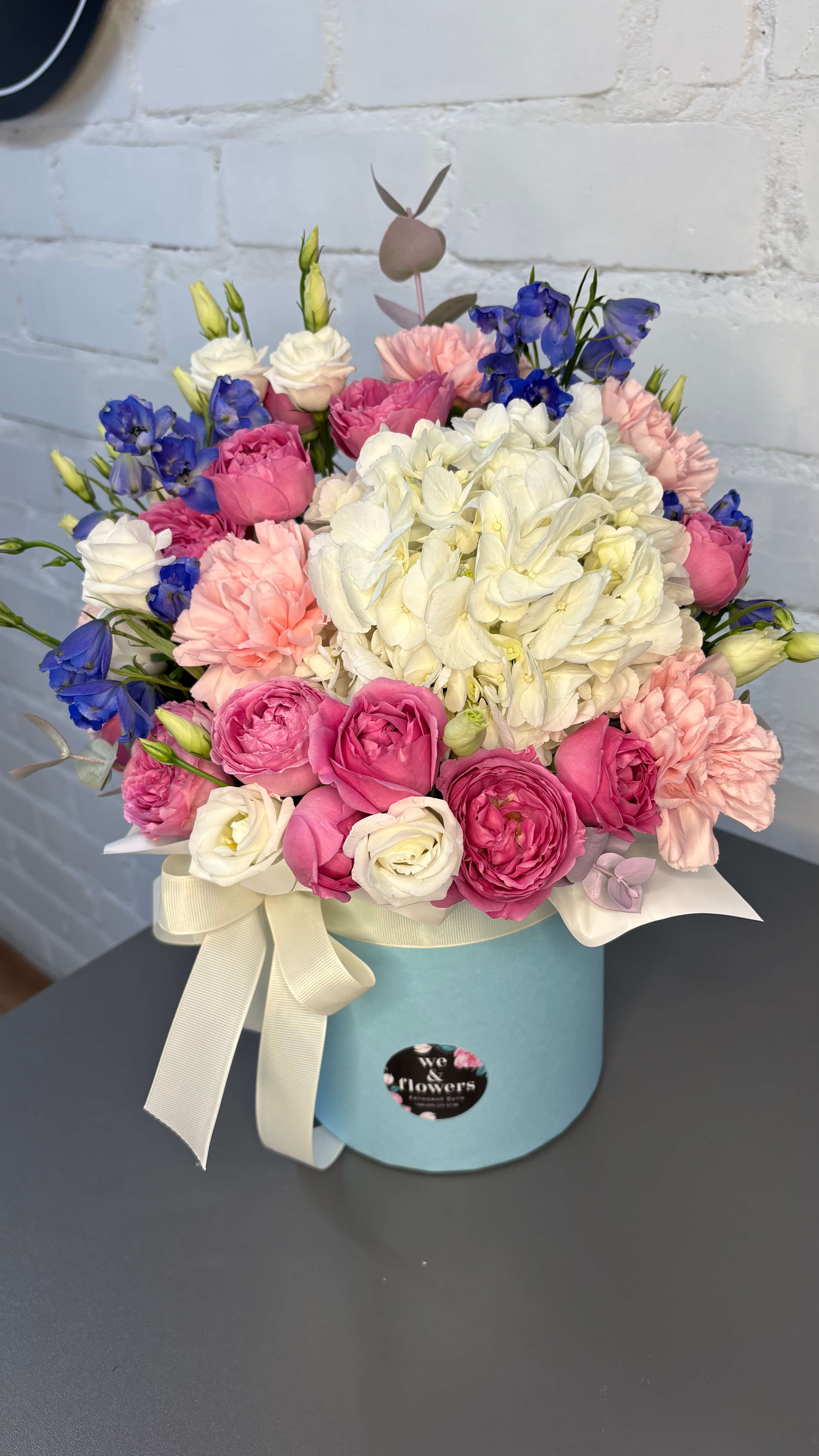 Композиція в коробці з трояндами, дельфініумом та гортензією