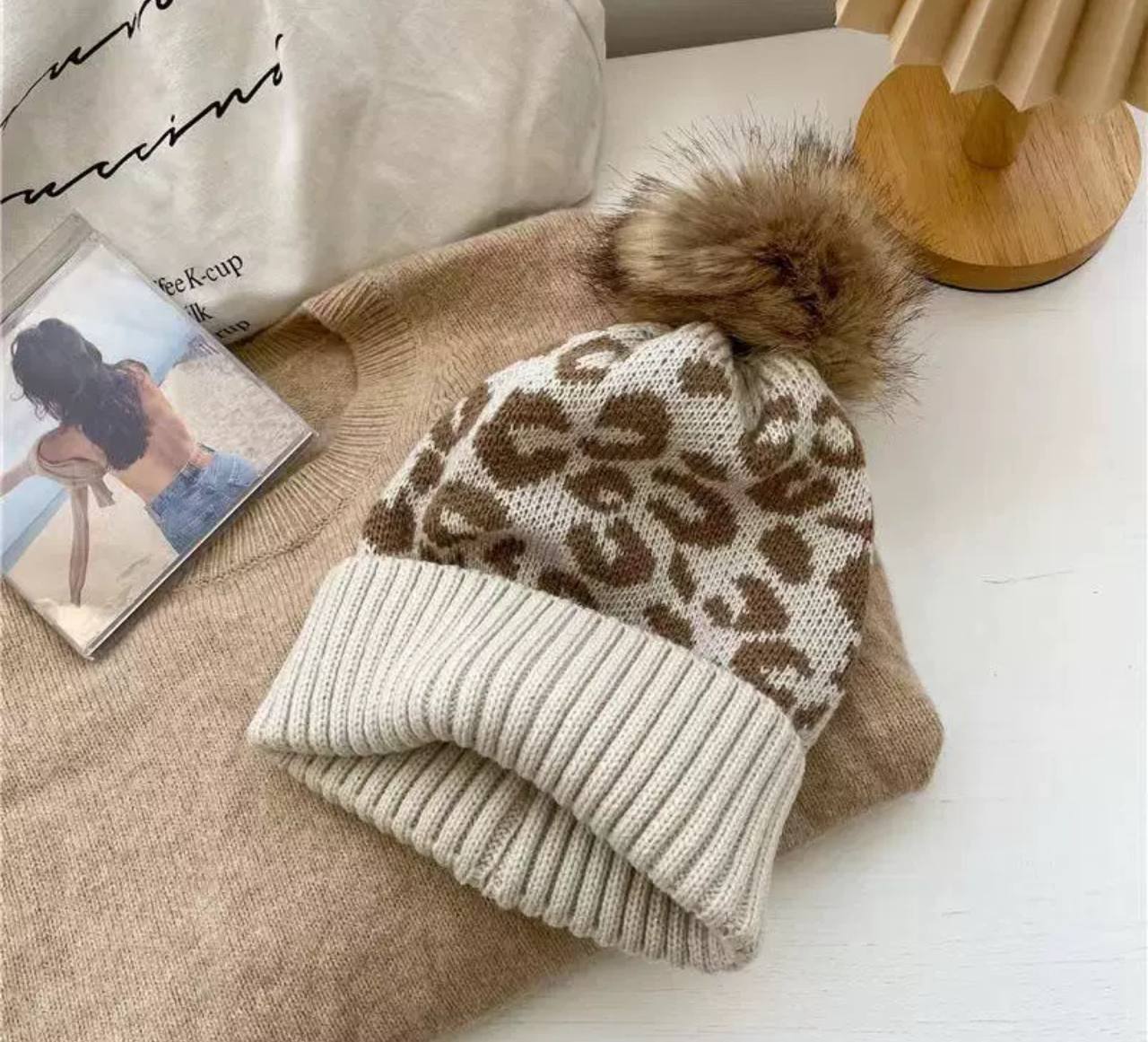 Тепла вязана шапка з леопардовим принтом та помпоном